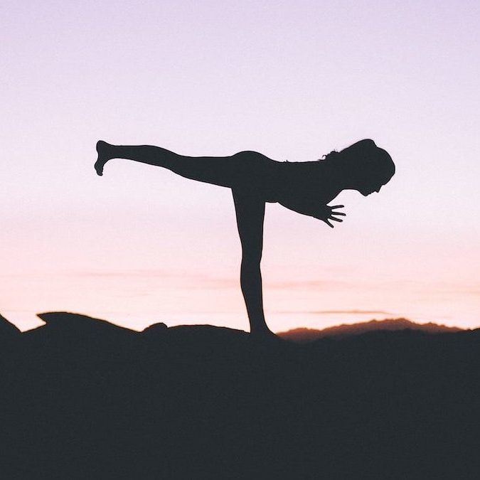 silhouette photography of woman standing on right foot